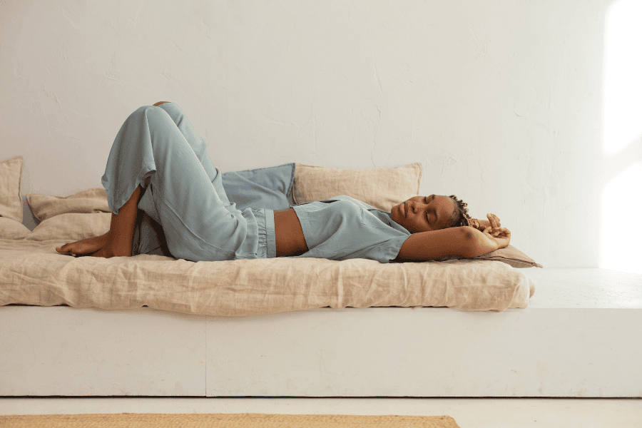 What Is Loungewear - A woman laying on a bad in pyjamas