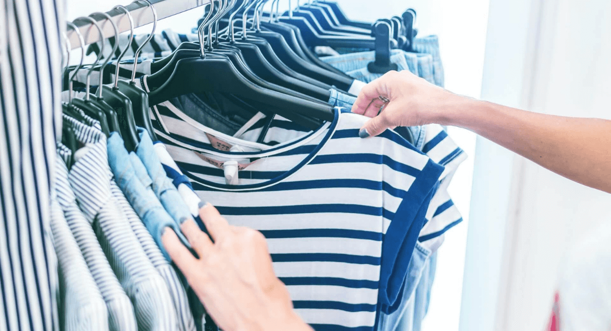 Fashion Industry Statistics - Person browsing through striped shirts